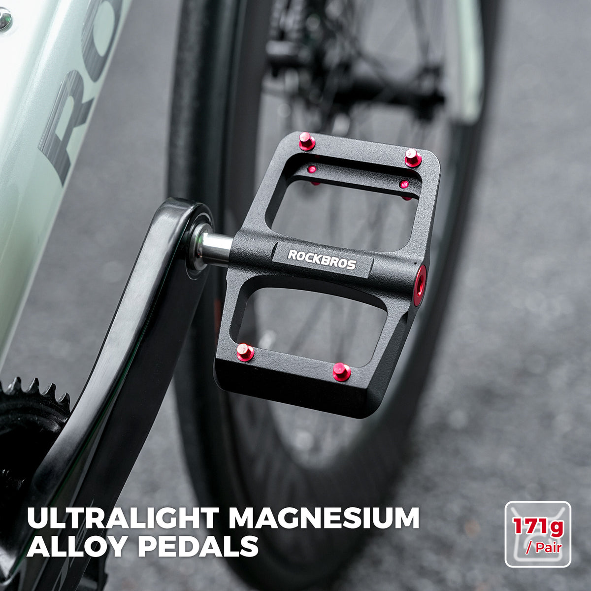 Pair of black ROCKBROS flat pedals with red traction pins and silver axles.