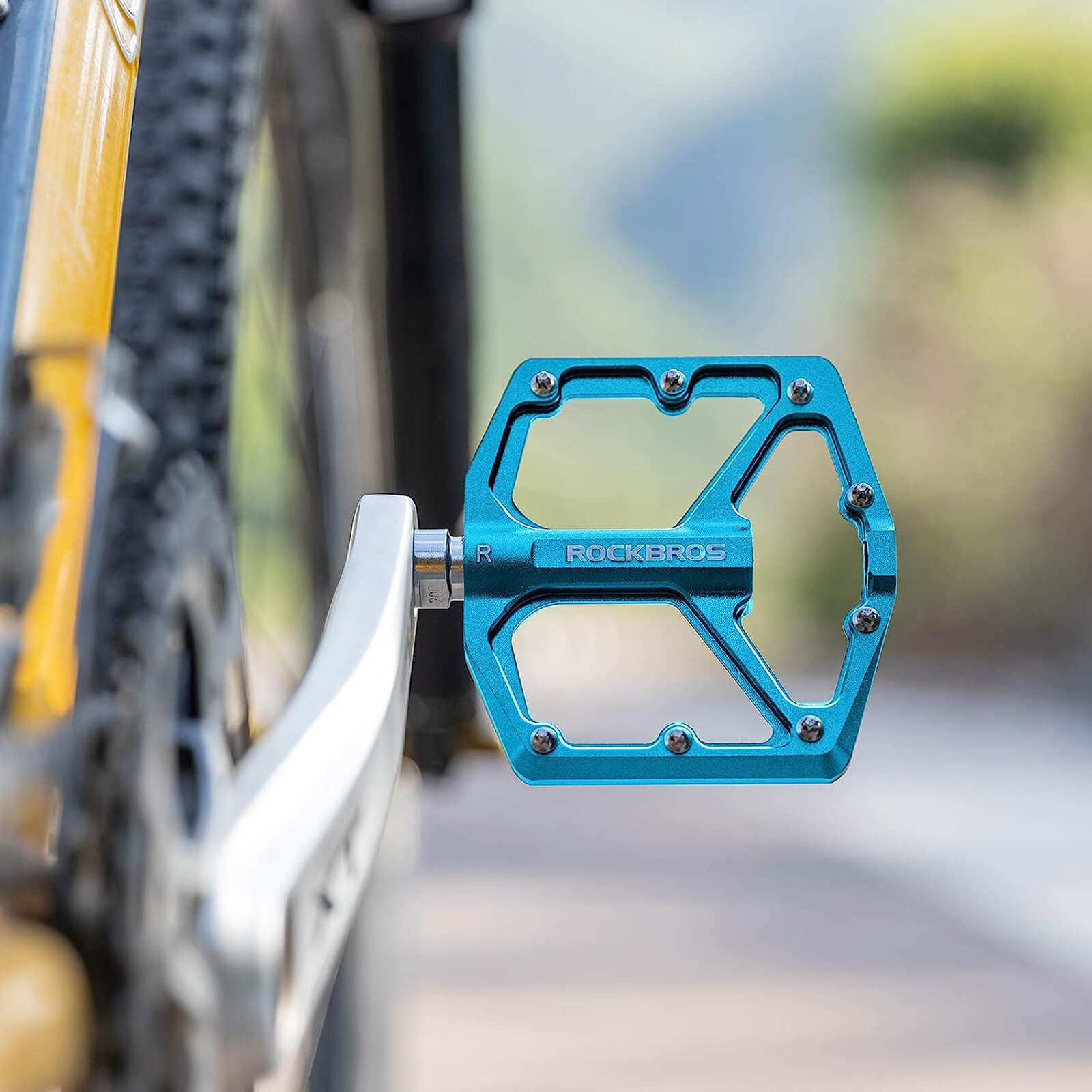rockbros Ultra Lightweight Flat Bike Pedals mounted on bicycle crank arm.
#color_blue